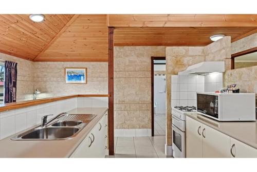 a kitchen with a sink and a stove at Discovery Parks - Bunbury Foreshore in Bunbury