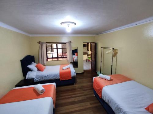 une chambre d'hôtel avec deux lits et une fenêtre dans l'établissement Qosqo Apartments 3, à Cusco