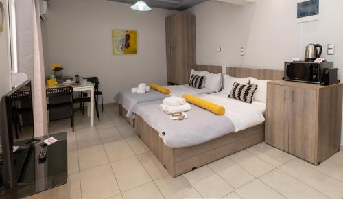 a bedroom with two beds and a desk and a television at Xenia_Apartments A7 in Kozani