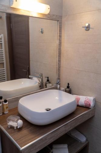 a bathroom with a white sink and a mirror at Xenia_Apartments A7 in Kozani