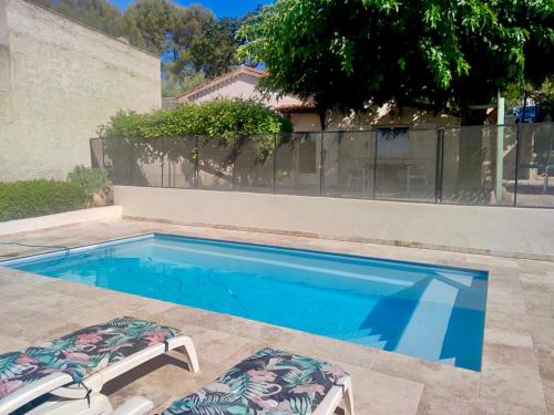 une piscine avec deux chaises longues à côté dans l'établissement Gite des Ecureuils, vue mer, piscine privée, parking, climatisation, à La Ciotat