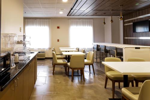a restaurant with tables and chairs in a cafeteria at Wingate by Wyndham Owensboro in Owensboro