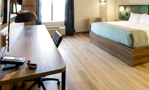 a hotel room with a bed and a desk at Wingate by Wyndham Owensboro in Owensboro