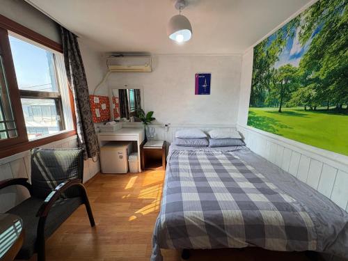 a bedroom with a bed and a desk in it at Gudeok Guesthouse in Seogwipo