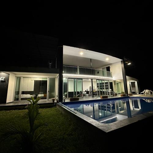 a large house with a swimming pool at night at XDfinca in Palermo
