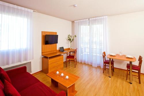 TV a/nebo společenská místnost v ubytování Séjours & Affaires Genève Saint Genis
