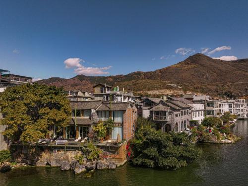 a group of buildings next to a body of water at Yang Liping Xianguo'an Moon Palace Villa, Shuanglang, Dali in Dali Shuanglang