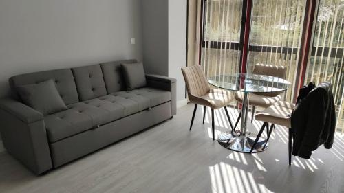 a living room with a couch and a table and chairs at Lugomar-Feijoo in Alpedrete