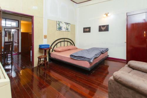 a bedroom with a bed and a table and a couch at OYO 75469 Baan Kong Hostel in Ban Talat Takua Pa