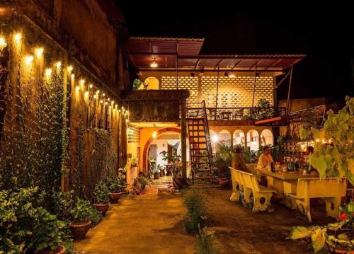 a building with a table and chairs and lights at OYO 75469 Baan Kong Hostel in Ban Talat Takua Pa