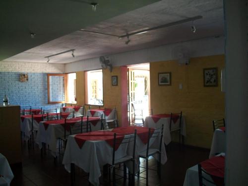 a dining room with red and white tables and chairs at Hotel La Posta del Dayman in Termas del Daymán