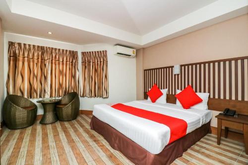 a hotel room with a large bed with red pillows at Collection O JA Siam City in Pattaya