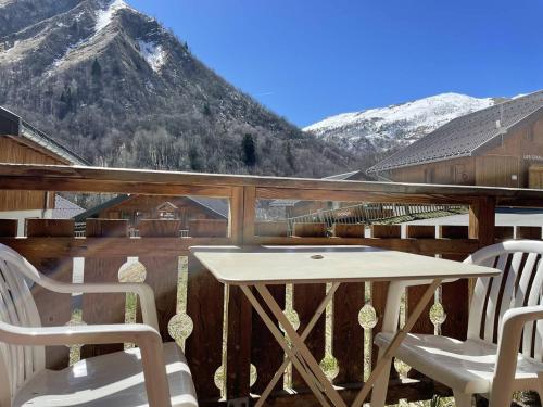 a white table and chairs on a balcony with mountains at Duplex - 4/5 personnes in Saint-Sorlin-dʼArves