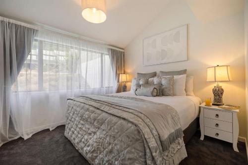 a bedroom with a large bed and a window at Distinctive Alpine Meadows in Queenstown