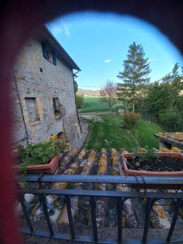 a view from a window of a stone building with plants at Fattoria di Rigone in Coltavolino