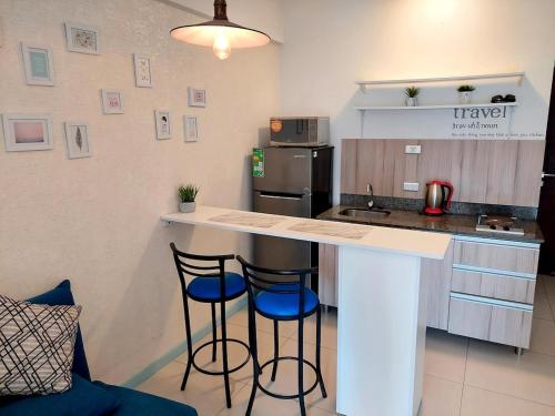 a kitchen with two bar stools and a counter top at Agradable departamento zona Equipetrol in El Pary