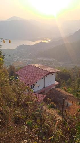 a house on a hill with the sun in the background at Kailash villa and restro in Pokhara