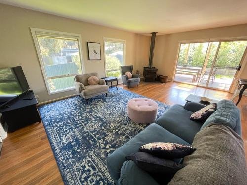 a living room with a blue couch and a tv at Cassini in Venus Bay