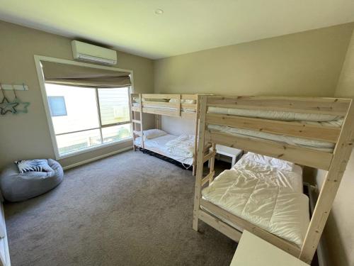 a room with two bunk beds and a window at Cassini in Venus Bay