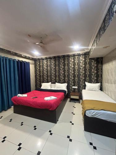 a bedroom with two beds and a red blanket at Hotel Horizon Lonavala in Lonavala