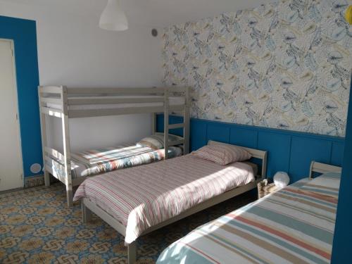 two bunk beds in a room with blue walls at Charmante maison avec cheminée, grand jardin et boxe chevaux in Saint-Hilaire-sur-Helpe