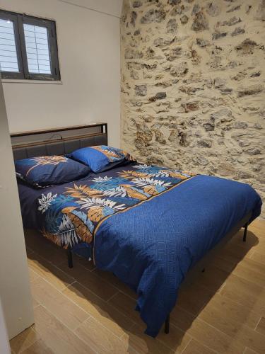 une chambre avec deux lits et un mur en pierre dans l'établissement Appartement T2 - Sète centre ville - A deux pas des Halles, à Sète