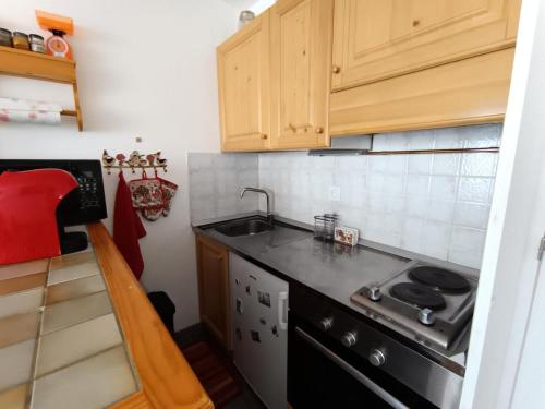 une petite cuisine avec un évier et une cuisinière dans l'établissement Résidence Chamoisiere - Grand studio 4 personnes MAE-8494, à Montgenèvre