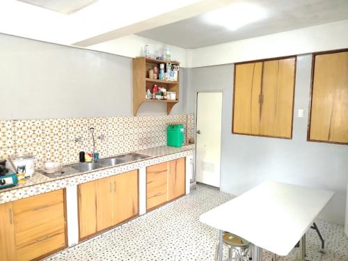 a kitchen with wooden cabinets and a sink at RKC Guest House in Coron