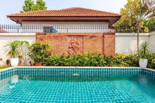 a swimming pool in front of a house at Luxury One Bedroom Private Pool Villa in Jomtien in Jomtien Beach