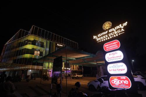 a group of signs in front of a building at night at Shree Durga Paradise in Kalyānpur