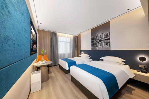 a hotel room with two beds and a tv at 逸方里广州北京路海珠广场地铁站店 in Guangzhou