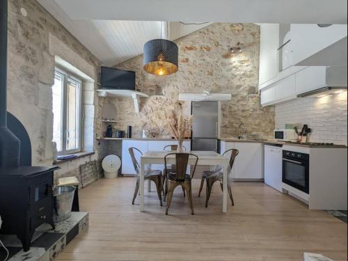 une cuisine avec une table et des chaises dans une pièce dans l'établissement Charmant loft atypique à Palavas, à Palavas-les-Flots