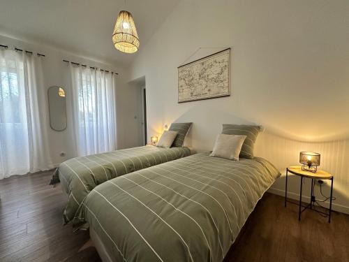 two beds sitting next to each other in a bedroom at Maison de vacances in Gondrin