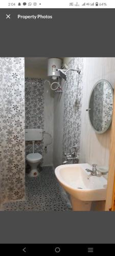 a bathroom with a sink and a toilet and a mirror at Hotel Blue Bird Nest in Garacherāma