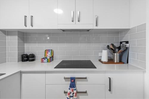 a kitchen with white cabinets and a counter top at Seaside Holiday Apartments Tugun in Gold Coast