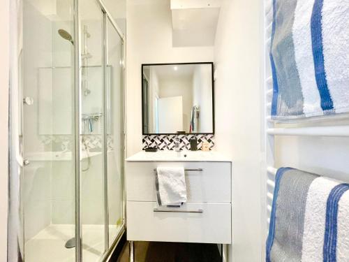 une salle de bain avec une douche en verre et un lavabo dans l'établissement Le Turquoise I Grand T2 lumineux I Proche Gare, à Lorient