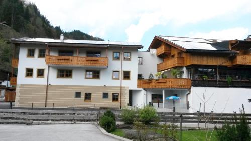 a large white building with wooden balconies at Gästehaus Rass in Lofer