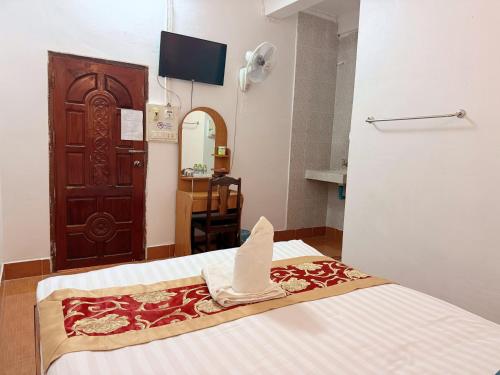 a bedroom with a bed with a towel on it at Vangvieng Sisavang Hotel in Vang Vieng