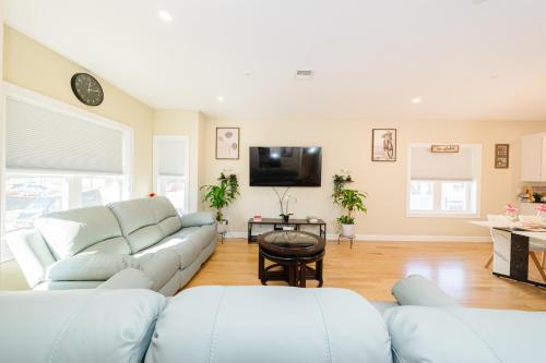 a living room with white furniture and a flat screen tv at 60-2 3BR Boston - Modern Apt near Franklin Park in Boston