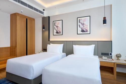 two beds in a hotel room at Iris Sarovar Portico in Gurgaon