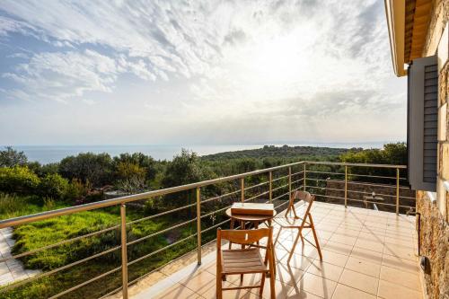 a balcony with two chairs and a table on it at Villa Eleni - Private Pool Retreat near Kardamili in Proástion