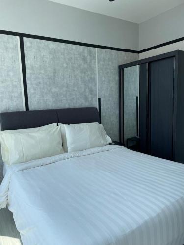 a large bed with white sheets and pillows at Suasana Suites Johor Bahru City Centre in Johor Bahru