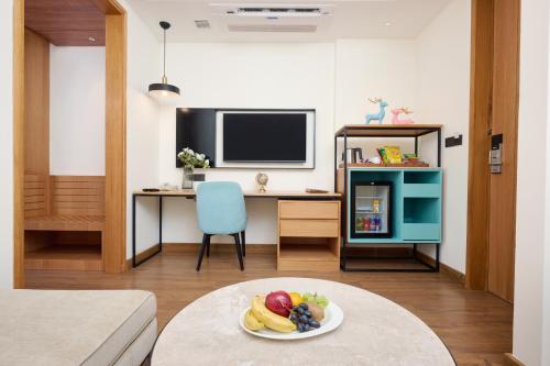 a living room with a table with a plate of fruit at Iris Sarovar Portico in Gurgaon