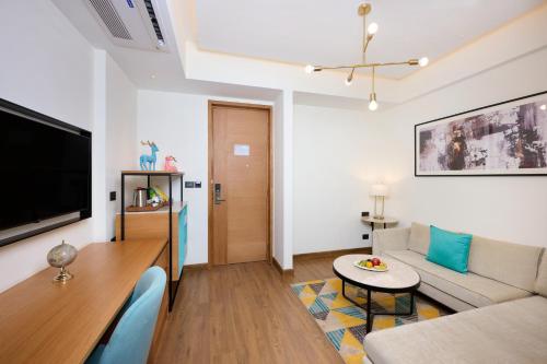 a living room with a couch and a table at Iris Sarovar Portico in Gurgaon