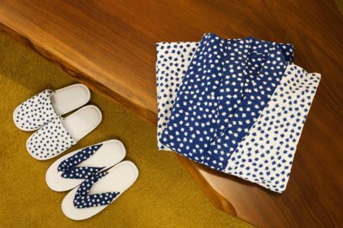 two pairs of slippers and an umbrella on a table at Andaz Tokyo - A Concept by Hyatt in Tokyo