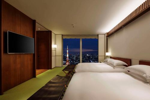 a hotel room with two beds and a flat screen tv at Andaz Tokyo - A Concept by Hyatt in Tokyo