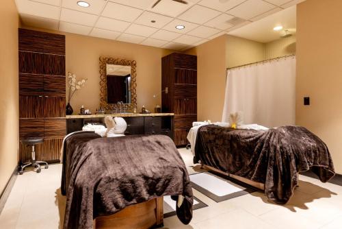 a salon with two beds and a mirror at Hilton Anatole in Dallas