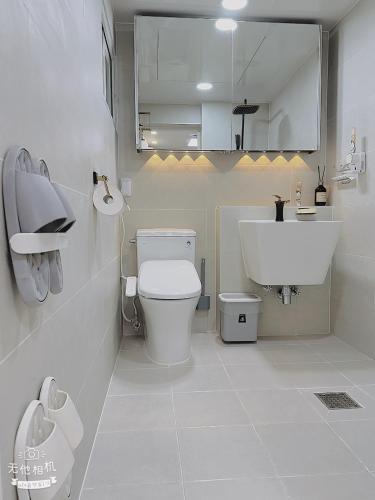 a white bathroom with a toilet and a sink at Jaha 79 in Seoul
