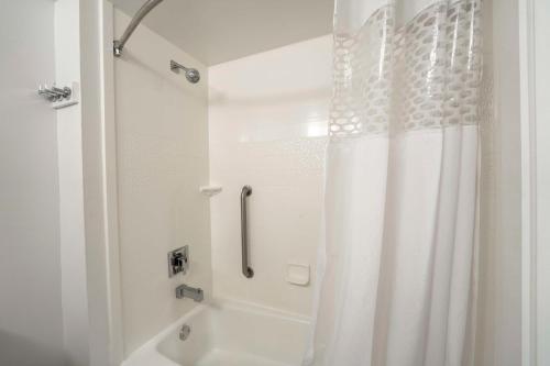 a bathroom with a shower with a white shower curtain at Hampton Inn Jacksonville South/I-95 at JTB in Jacksonville