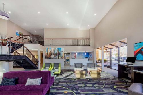 a living room with a purple couch and chairs at La Quinta by Wyndham Oakland - Hayward in Hayward